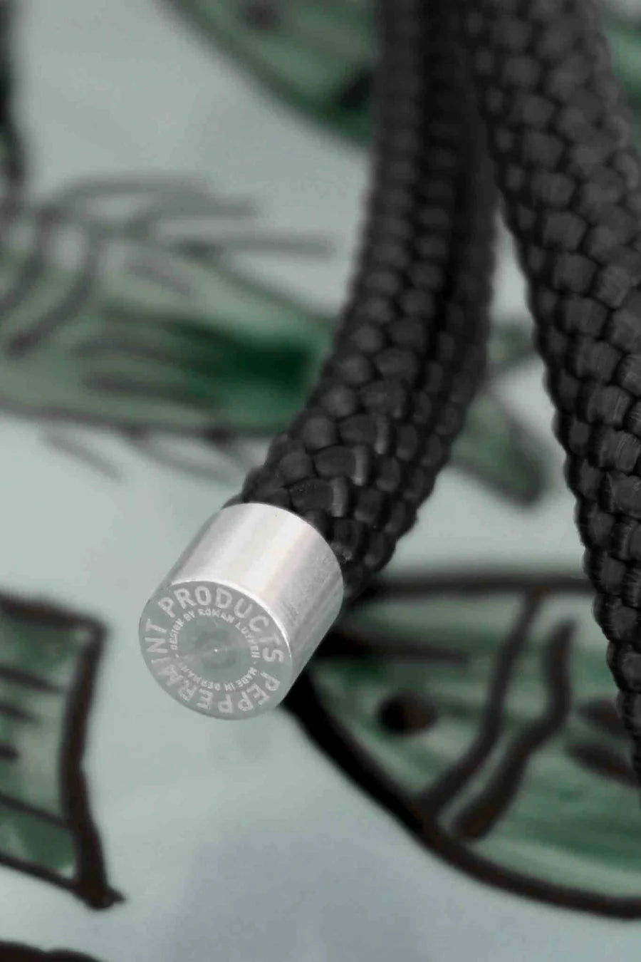 Close-up of peppermint rope hanger showcasing its braided texture and metallic end detail.