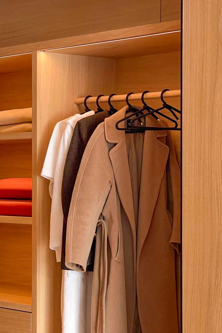 Peppermint rope hanger displaying coats and shirts in a wooden closet for efficient organization.