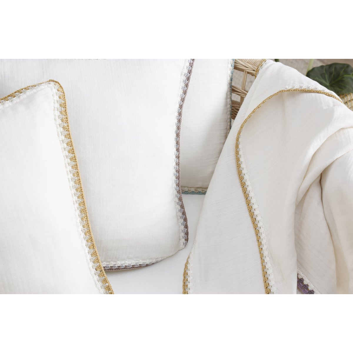 White pillows with gold trim on a white background