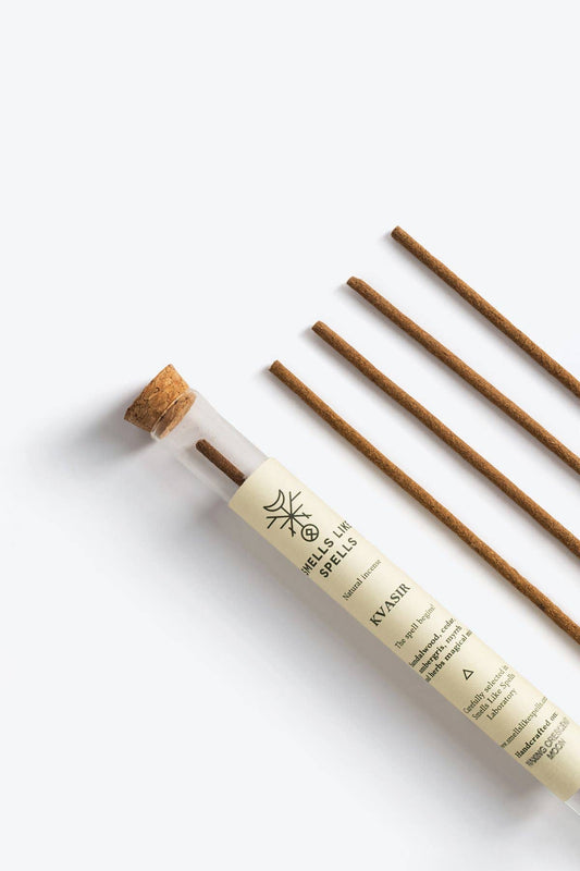 Incense sticks in a cylindrical holder on a white background