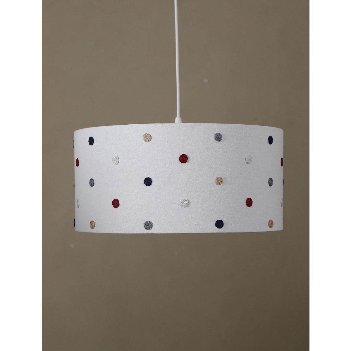 White lampshade with colorful polka dots on a beige background