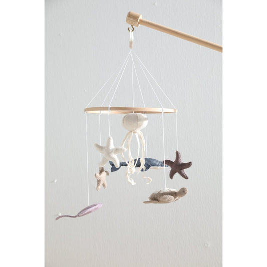 Children's mobile with sea-themed decorations on a plain background