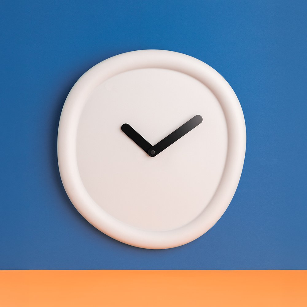 White wall clock with black hands on a blue and orange background