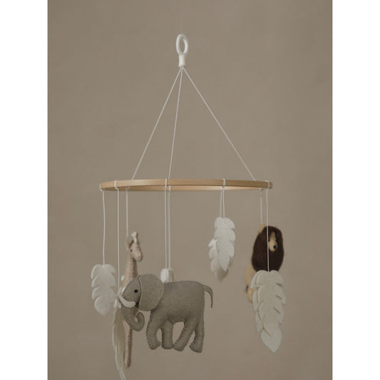 Children's mobile with elephant, giraffe, and monkey on a beige background