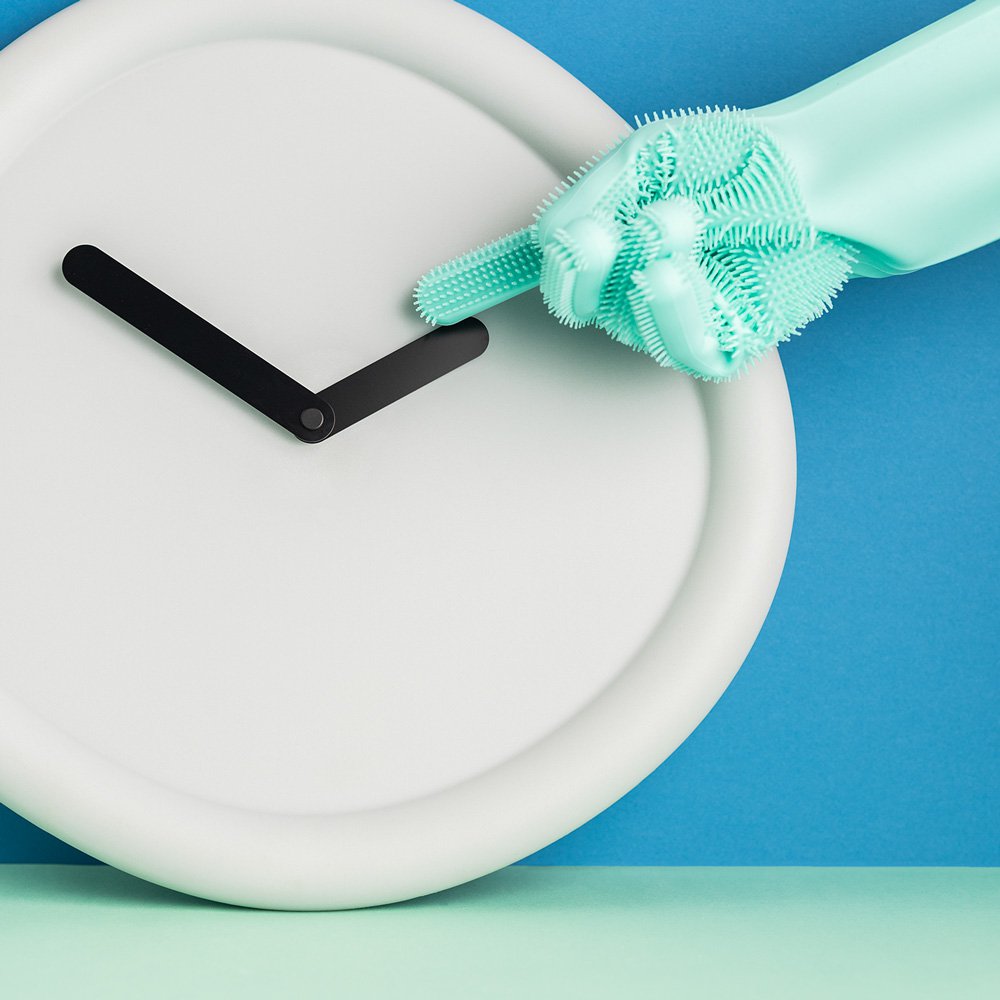 White clock with a green scrub brush on a blue background