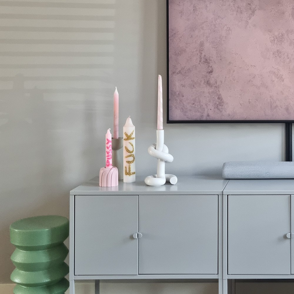 Decorative candles on a shelf with a modern interior setting