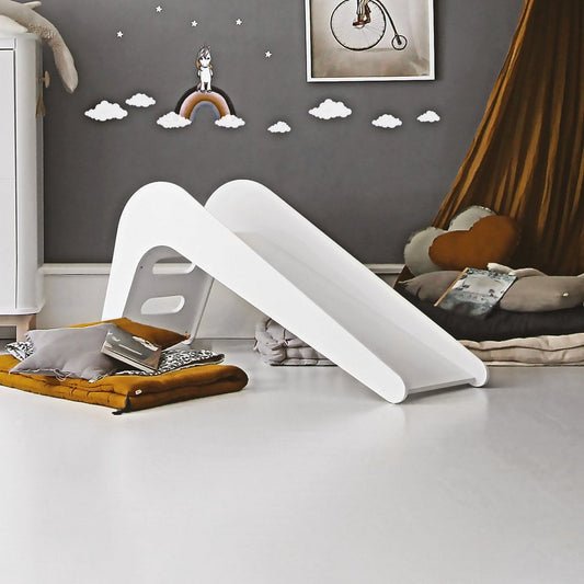 White children's slide in a room with toys and decorations on the floor.