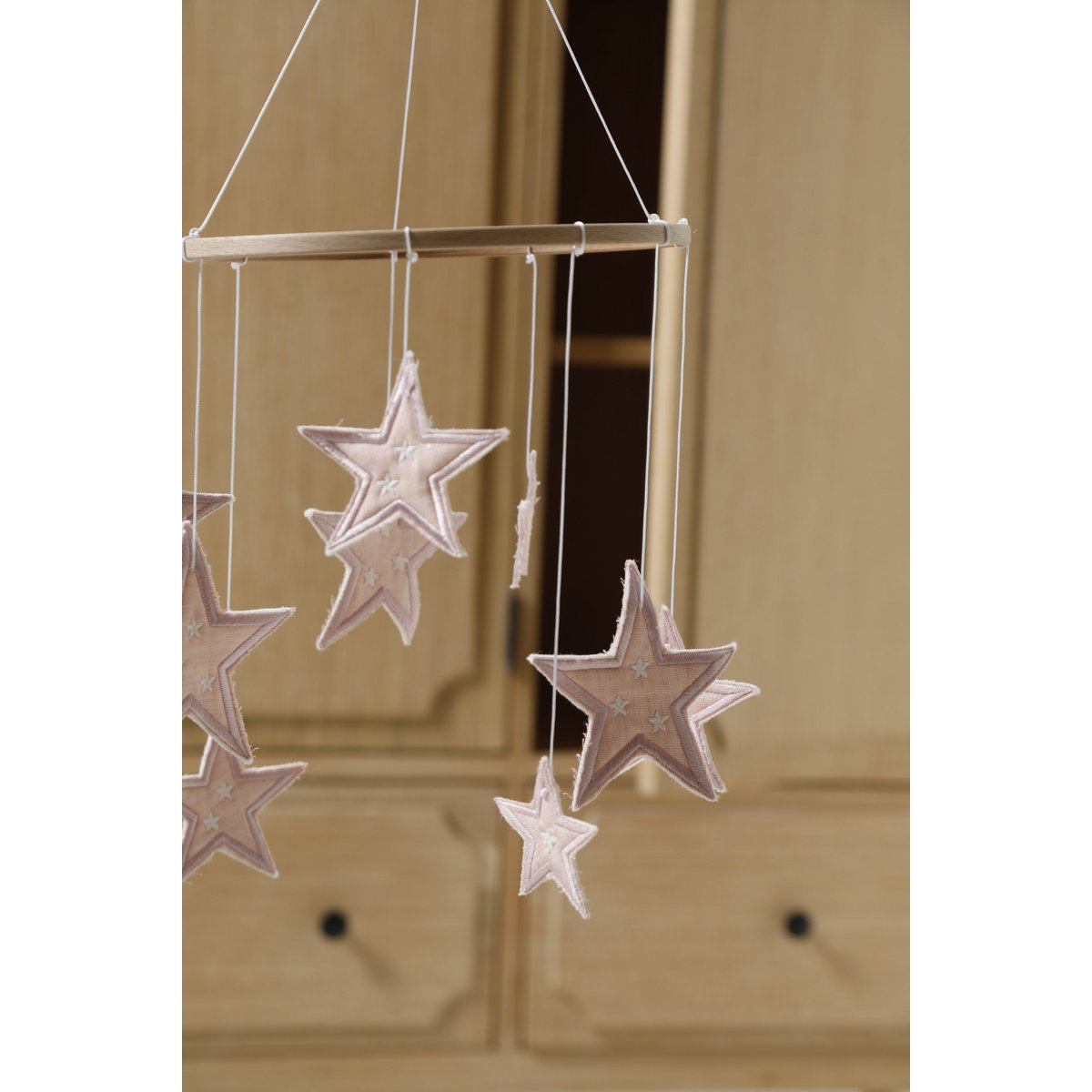 Decorative hanging mobile with star shapes against a wooden background