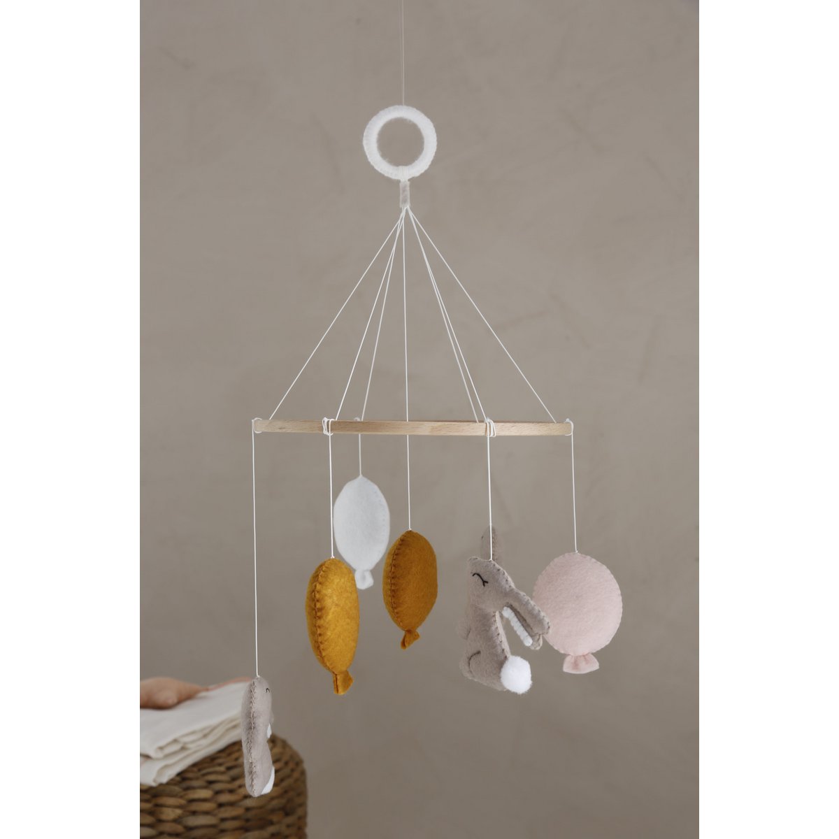 Decorative hanging mobile with colorful hanging elements against a neutral background