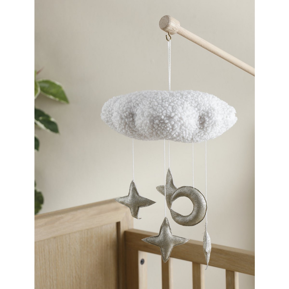 Decorative cloud mobile with stars and moons hanging above a crib.