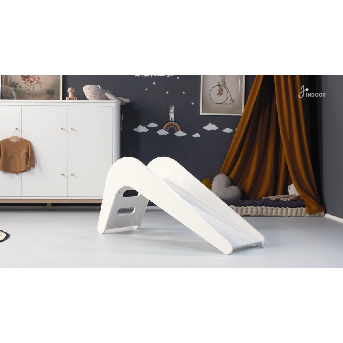 White children's slide in a room with a white dresser and decorative items.