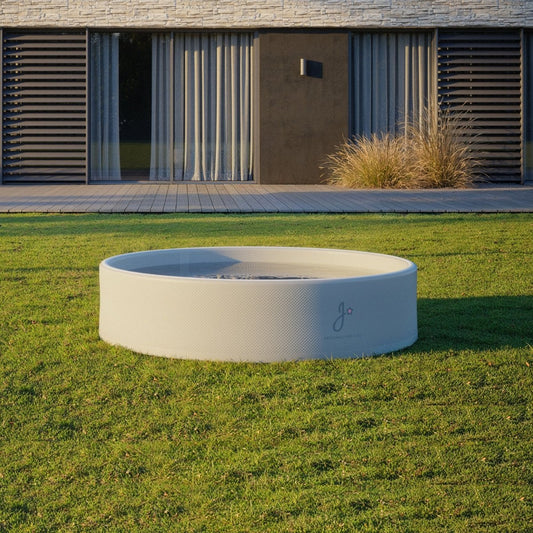 Modern kids pool in a grassy area with a building in the background