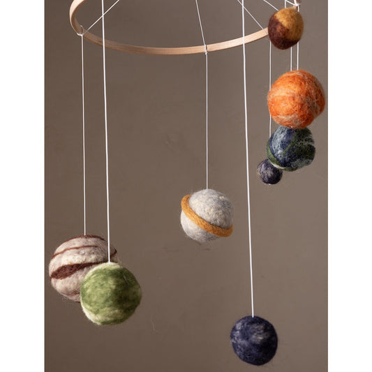 Decorative hanging mobile with felted balls on a plain background