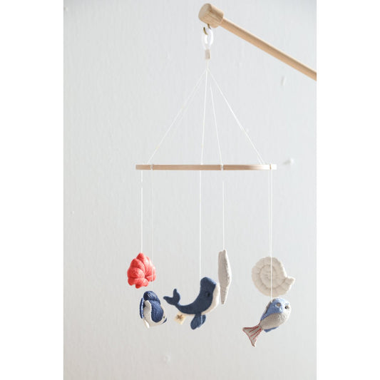 Decorative hanging mobile with sea-themed toys on a plain background