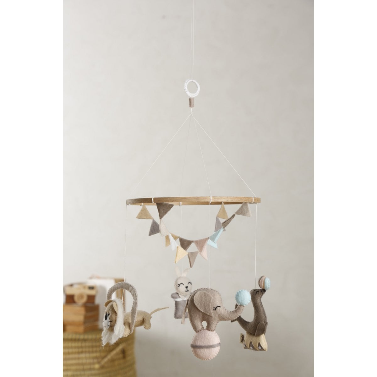 Baby mobile with hanging toys against a plain wall