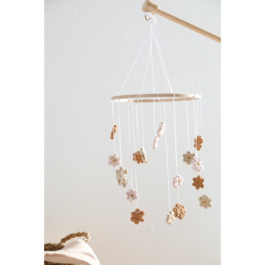 Decorative hanging mobile with flowers against a white wall