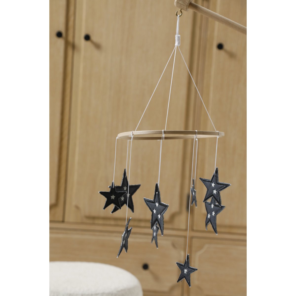 Star-shaped hanging mobile with black stars on a wooden background