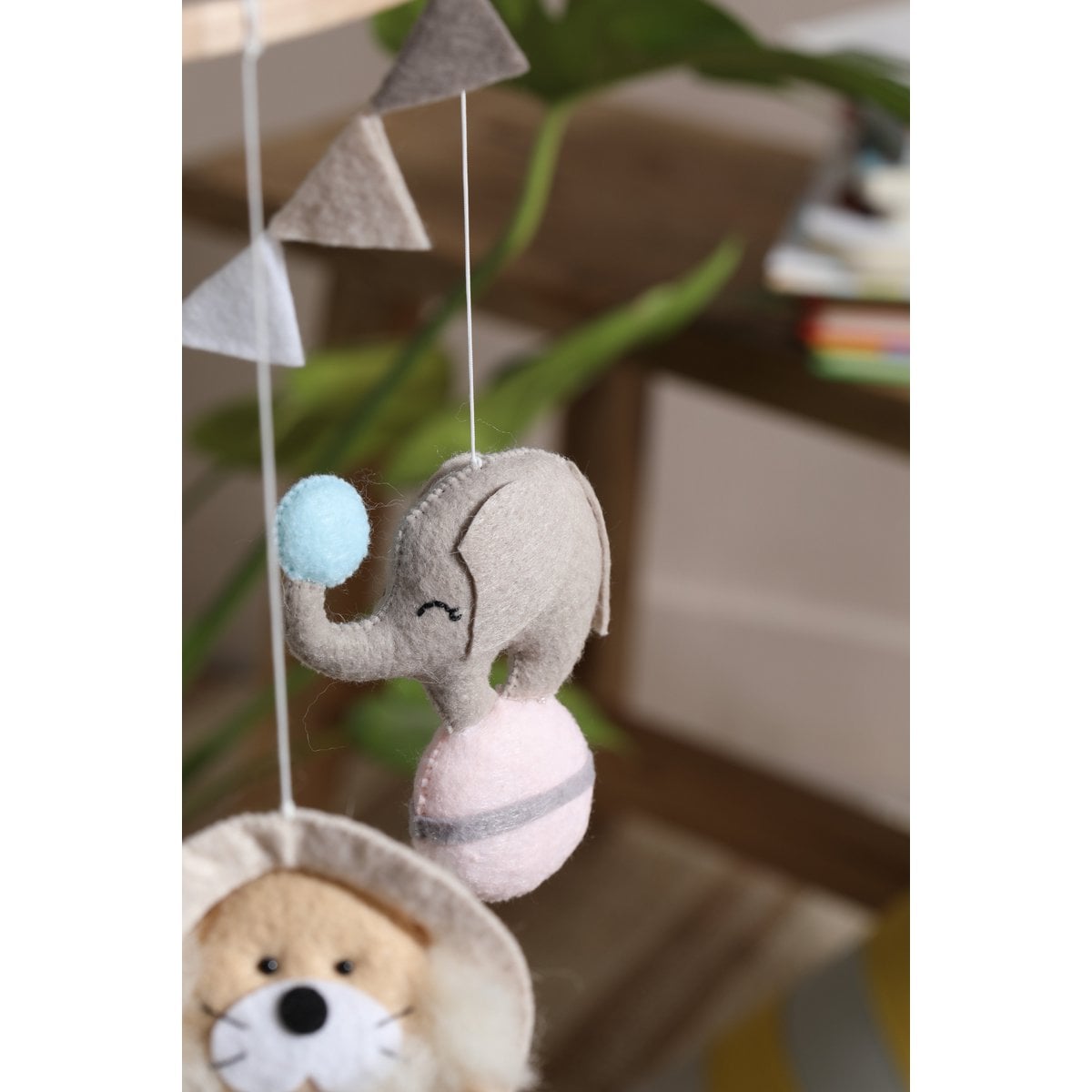 Children's mobile with elephant and bear toys hanging from triangles.