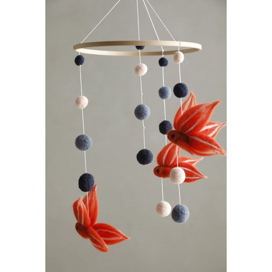 Decorative mobile with goldfish and colorful balls on a plain background