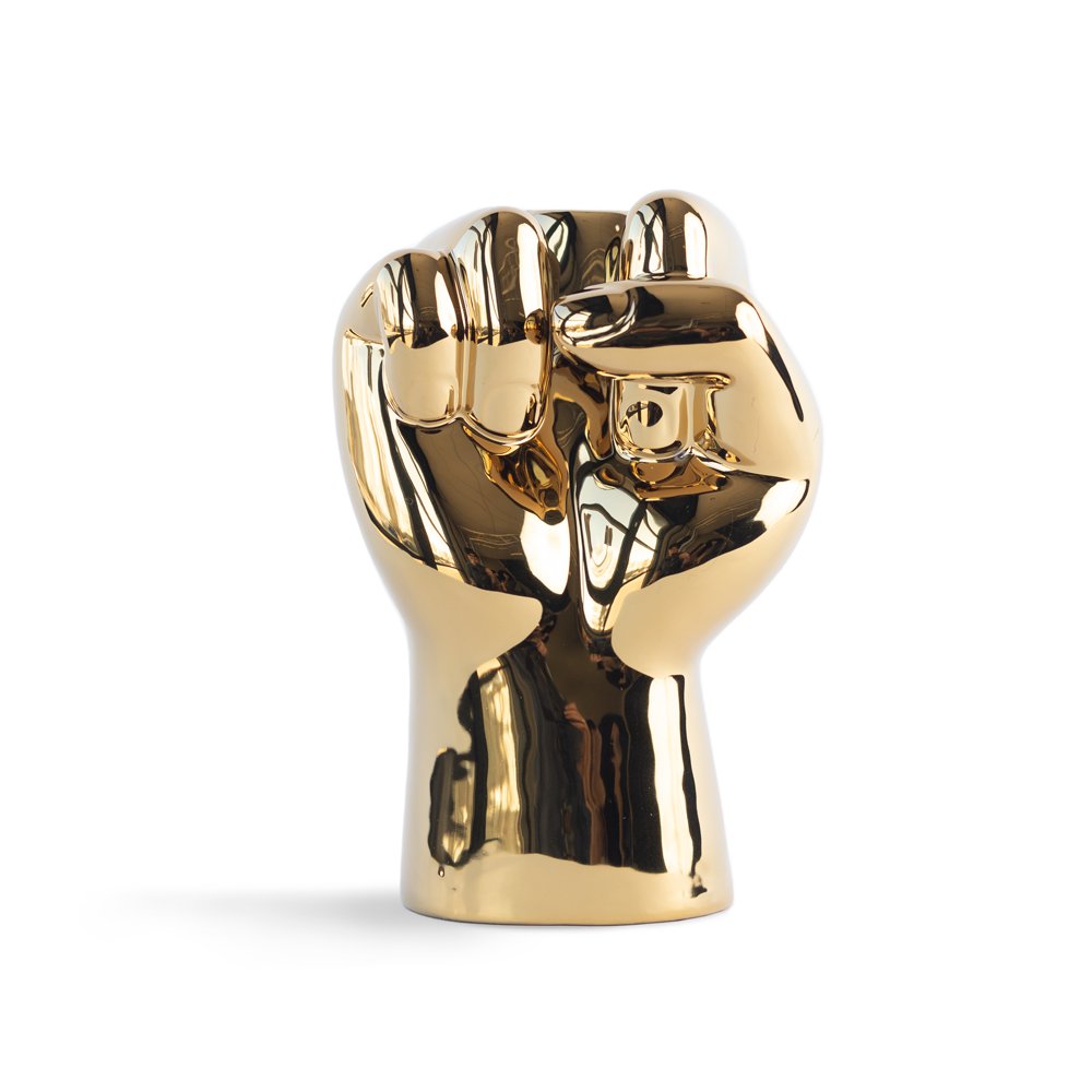 Gold-colored sculpture of two interlocked hands on a white background