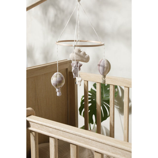 Knitted mobile with clouds and stars hanging over a crib