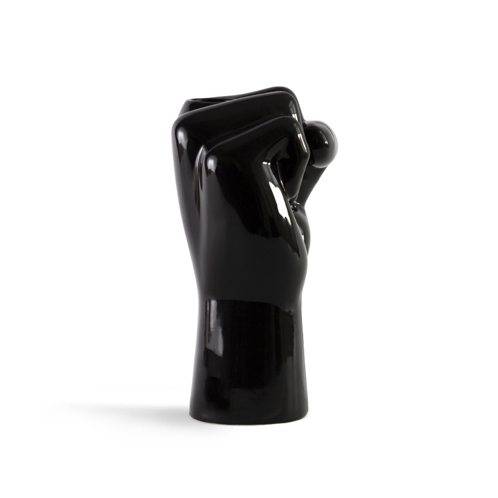 Black ceramic vase shaped like a hand holding a heart on a white background