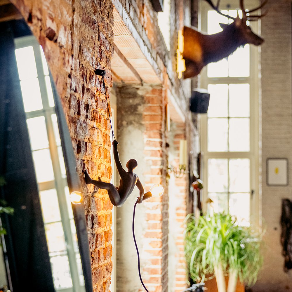 Decorative wall light fixture on a brick wall with a window in the background