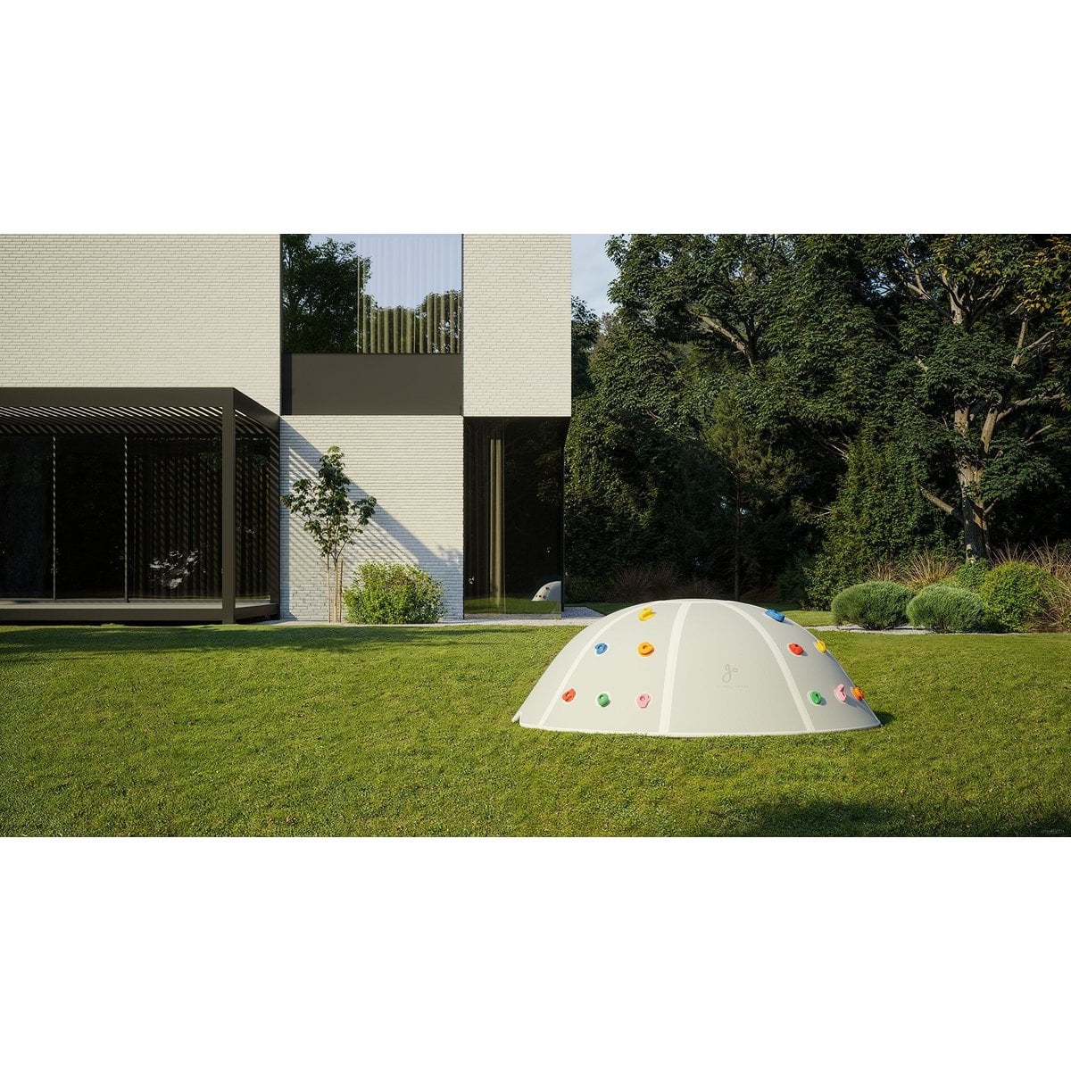 Children's play dome with colorful buttons on a grassy area, surrounded by trees and a building.