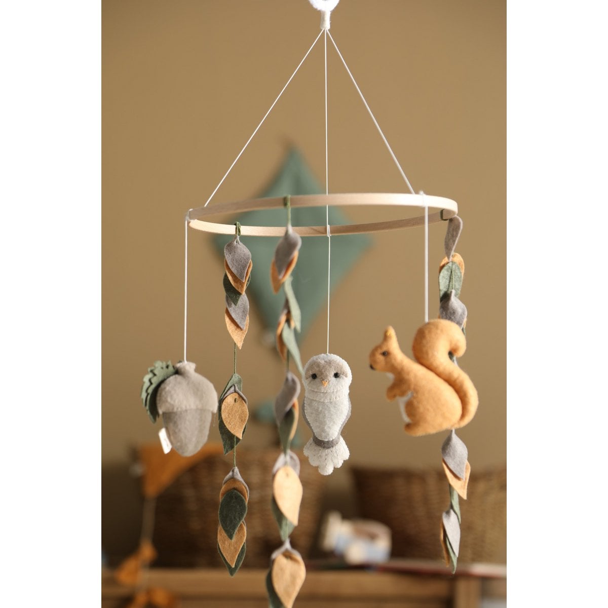 Children's mobile with hanging plush animals against a neutral background