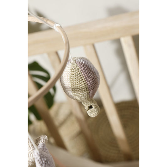 Crocheted hot air balloon mobile hanging from a chair