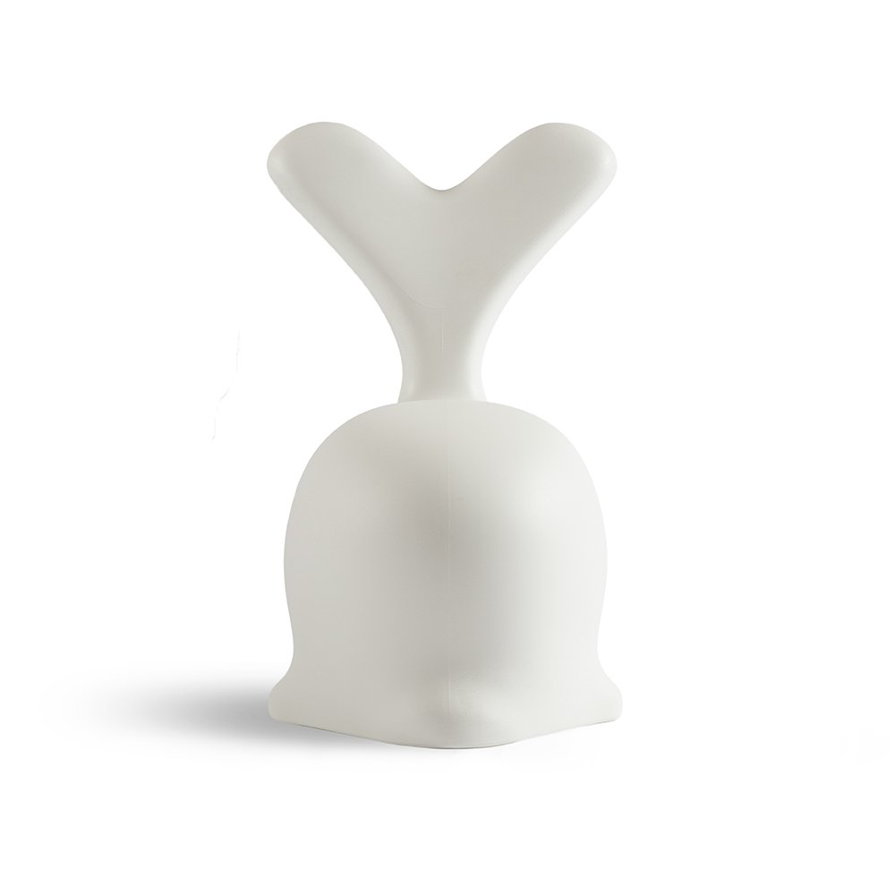 White ceramic sculpture of a stylized face on a white background