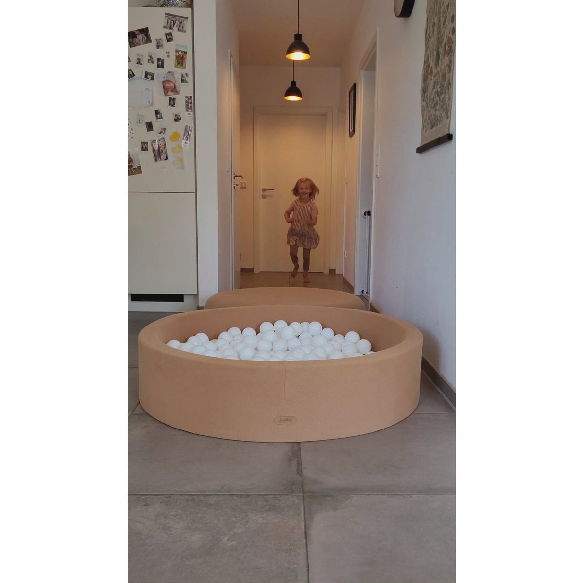 Child playing with a ball pit in a home setting