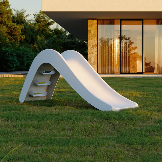 White slide on grass in front of a modern building
