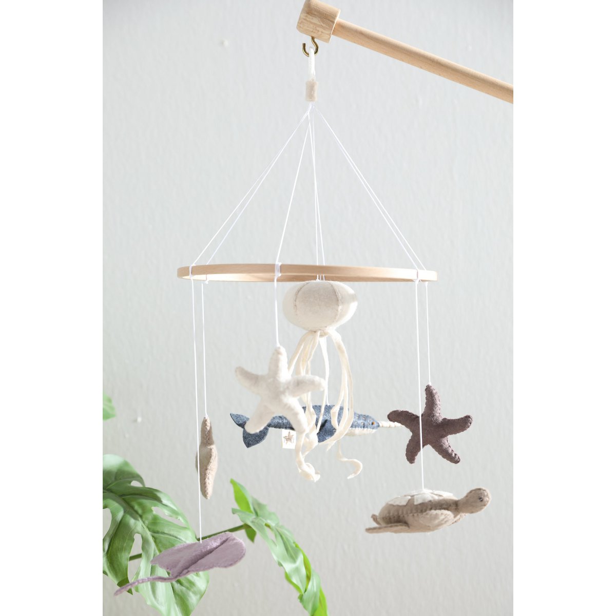 2 Stories Decorative hanging mobile with starfish, shells, and seagulls on a white background
