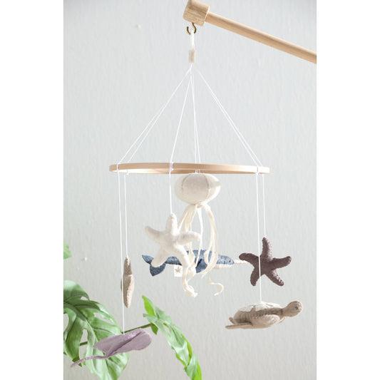 2 Stories Decorative hanging mobile with starfish, shells, and seagulls on a white background