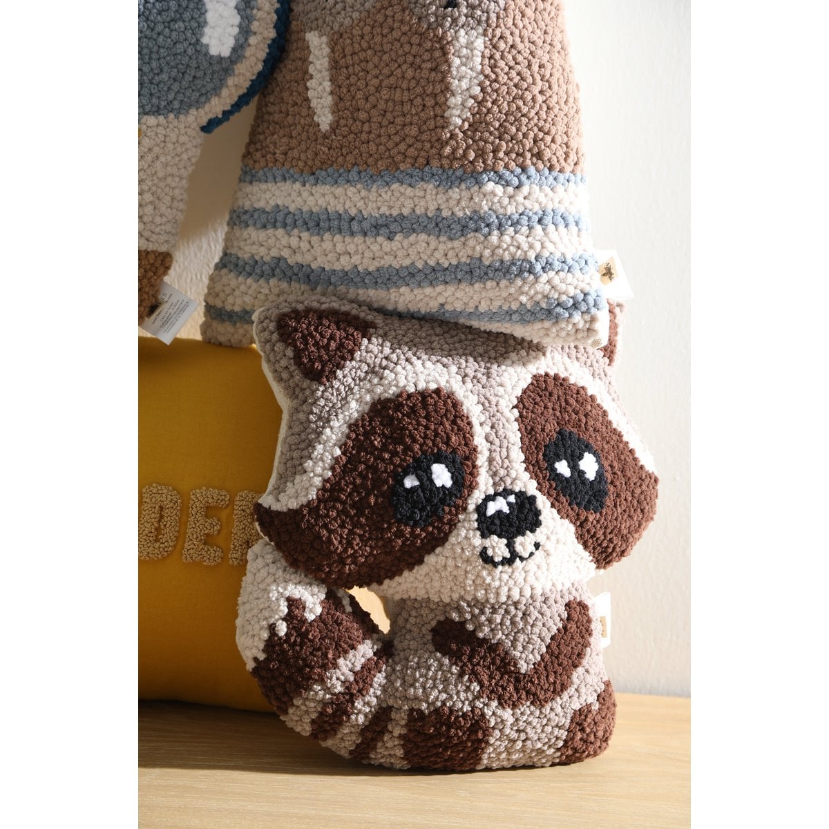 Textured animal-shaped pillow with a striped pattern on a wooden surface