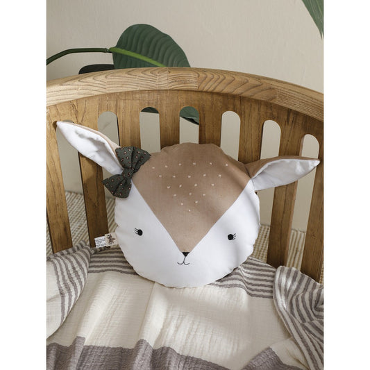 Plush toy shaped like a deer head with a bow on a wooden chair.