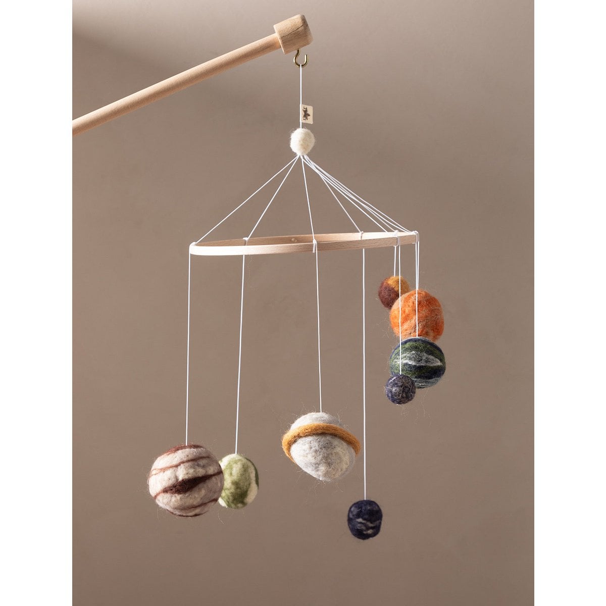 Hanging mobile with colorful spherical elements on a beige background