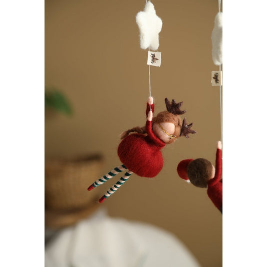 Decorative hanging figure of a fairy in a red dress with striped leggings against a neutral background.
