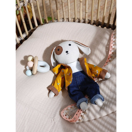 Stuffed animal toy with a yellow raincoat in a crib
