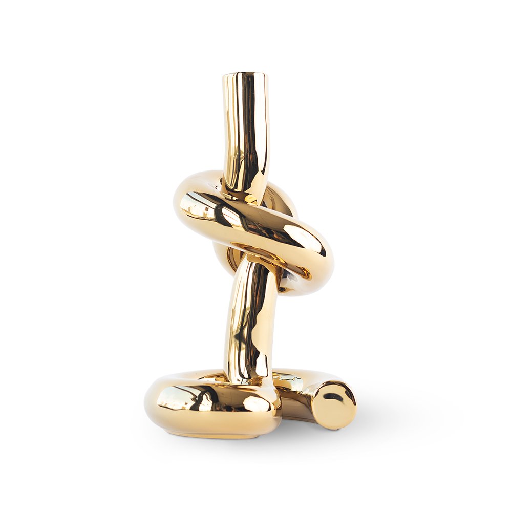 Gold knot-shaped decorative object on a white background