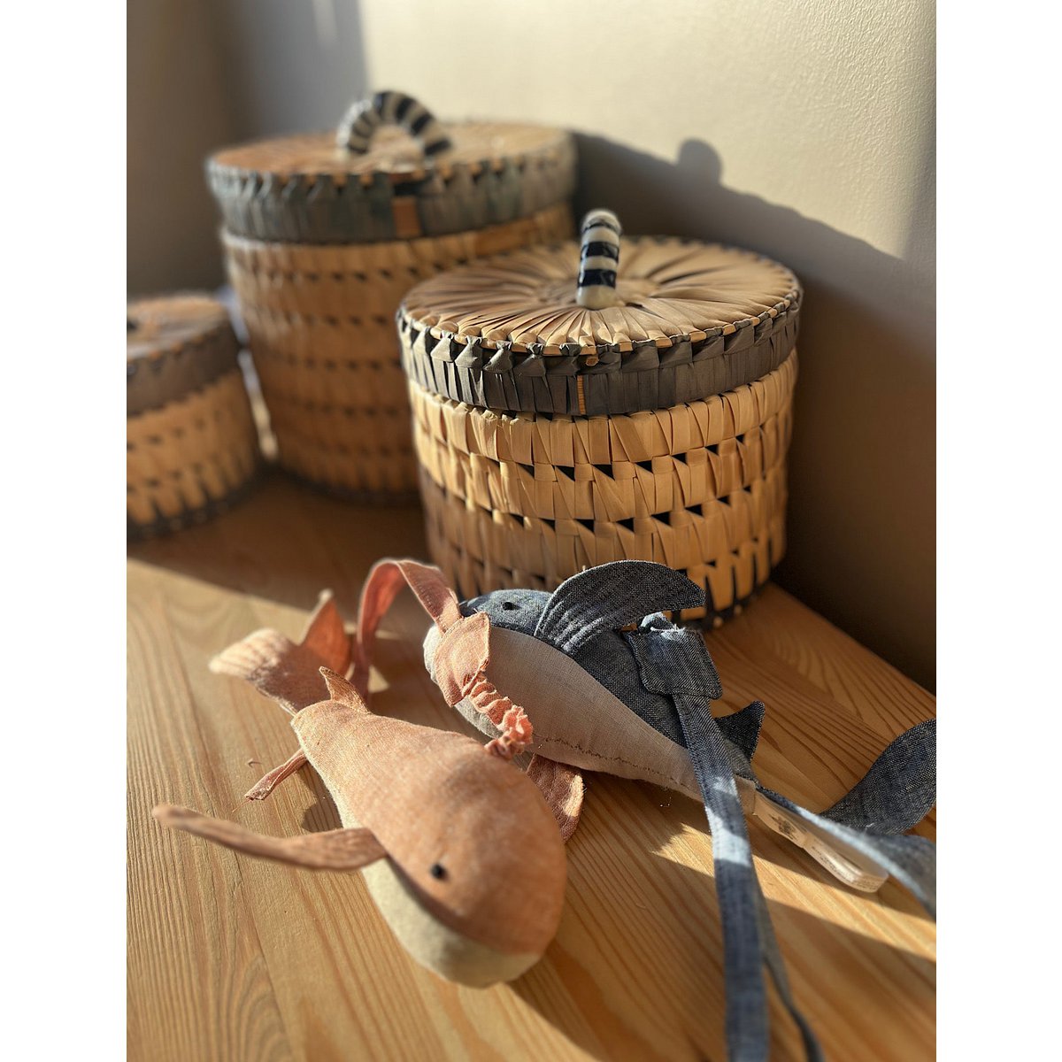 Woven baskets with decorative lids on a wooden surface