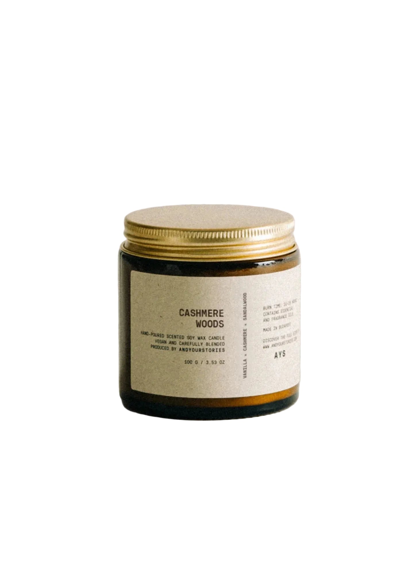 Candle with a gold lid and label on a light gray background