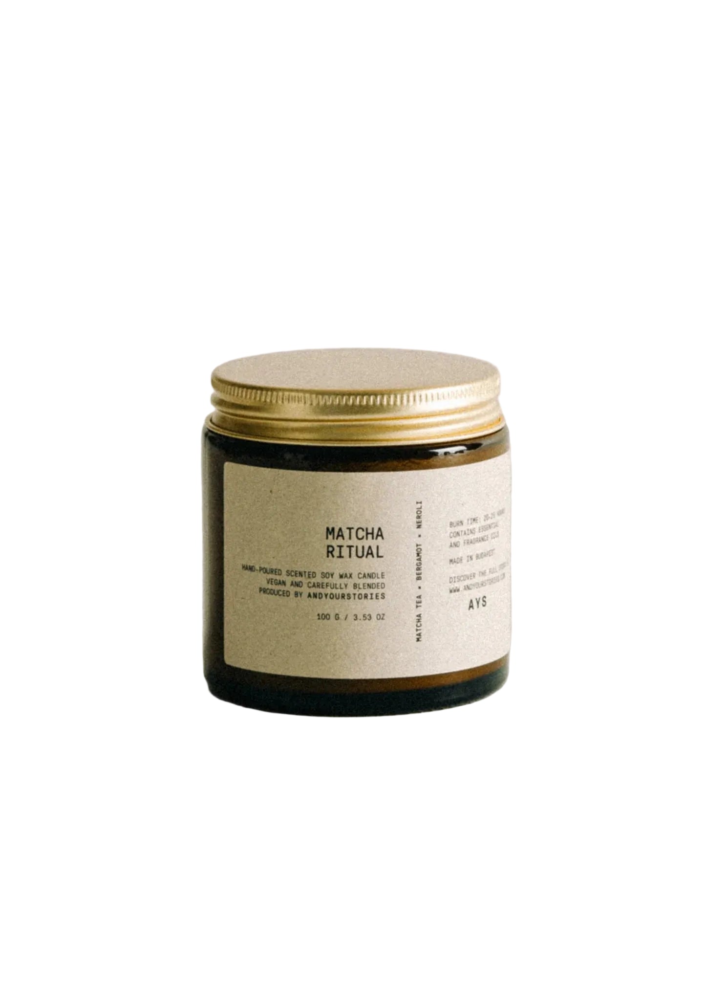 Candle with a gold lid and white label on a light gray background