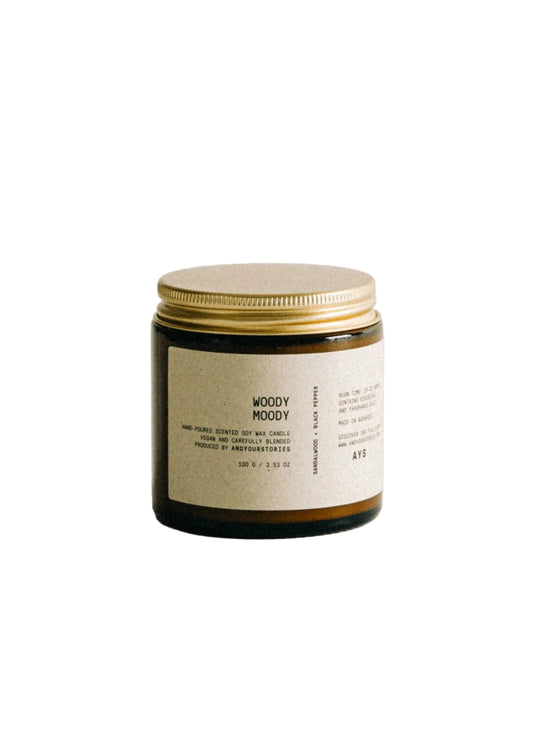 Candle with a gold lid on a light gray background
