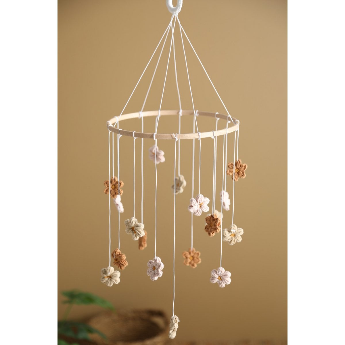 Decorative hanging mobile with flowers against a beige background