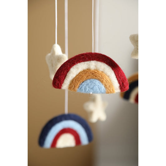 Colorful rainbow-shaped hanging decor with stars on a neutral background