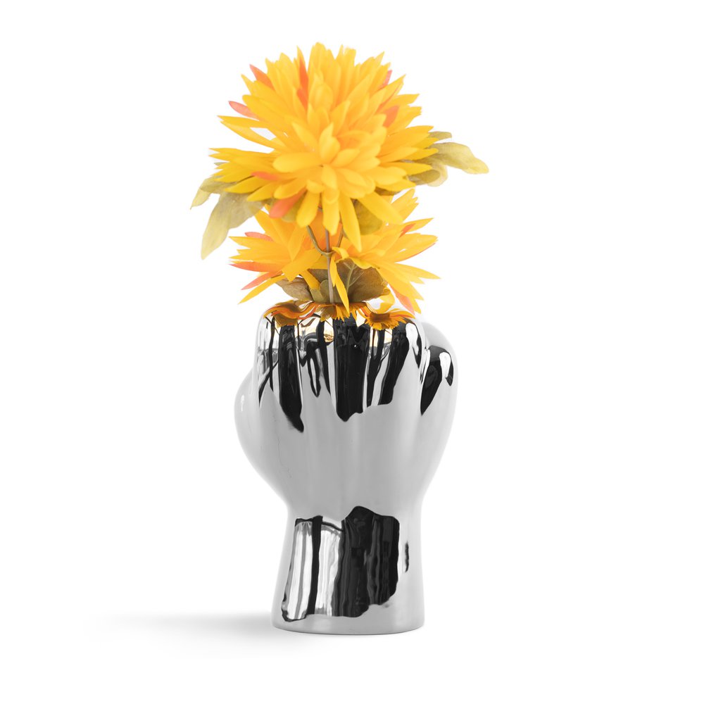 Vase shaped like a hand holding yellow flowers on a white background