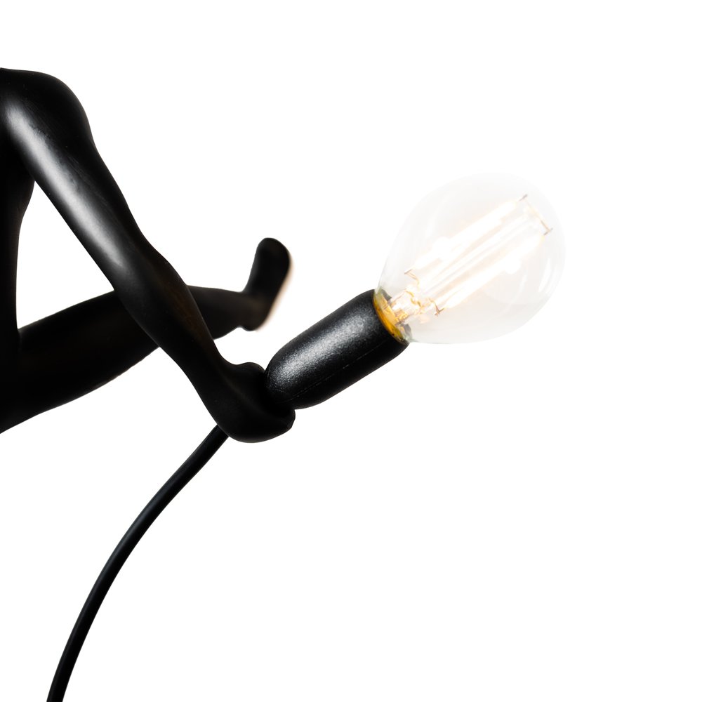 Black lamp with a visible light bulb on a white background