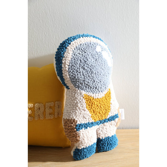 Textured pillow with blue, white, and yellow pattern on a wooden surface.